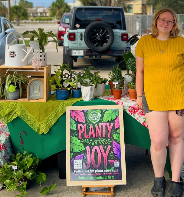 Plant sale! Galv Island Market A young woman hosts a plant booth